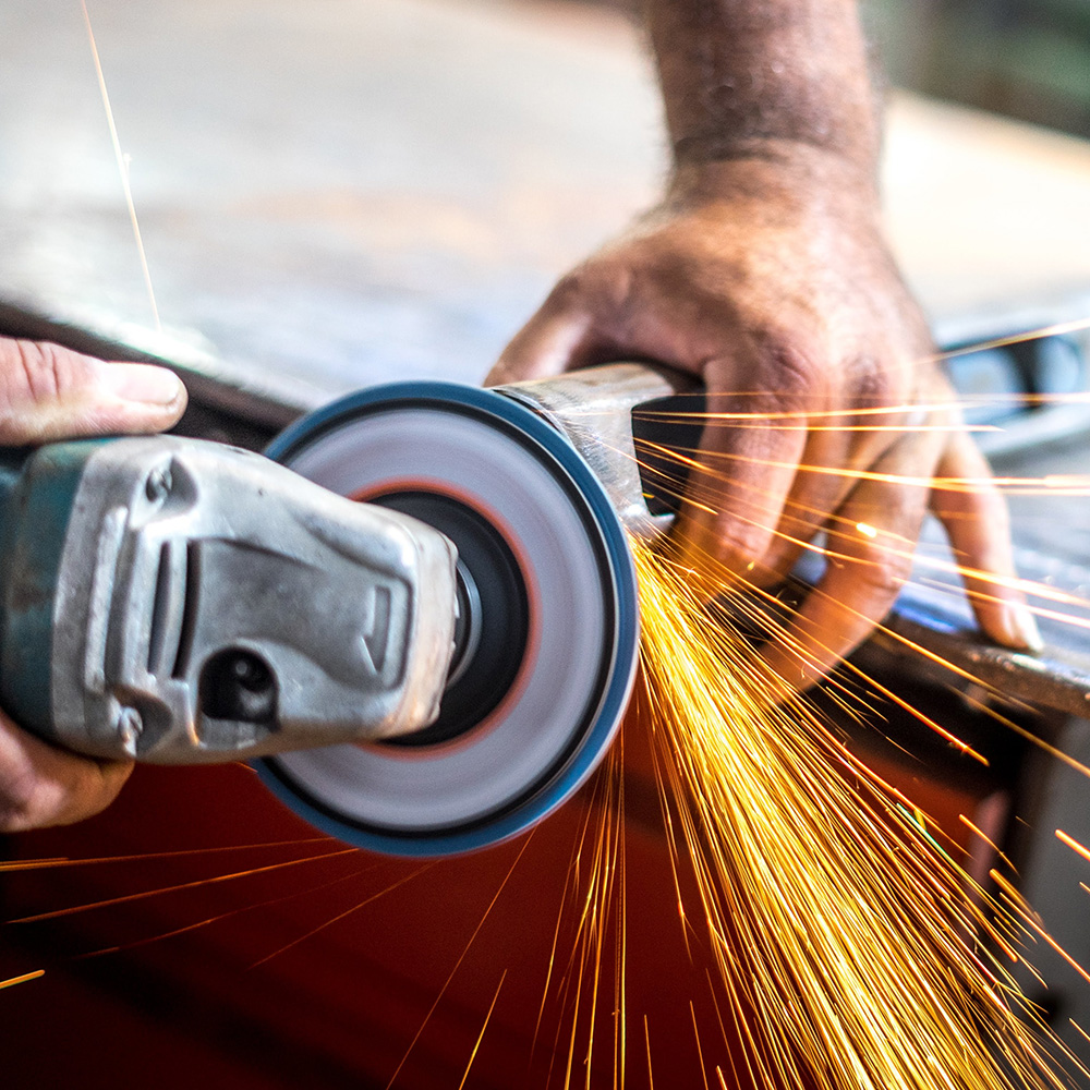 man-working-with-angular-grinder-with-sparkles-from-it